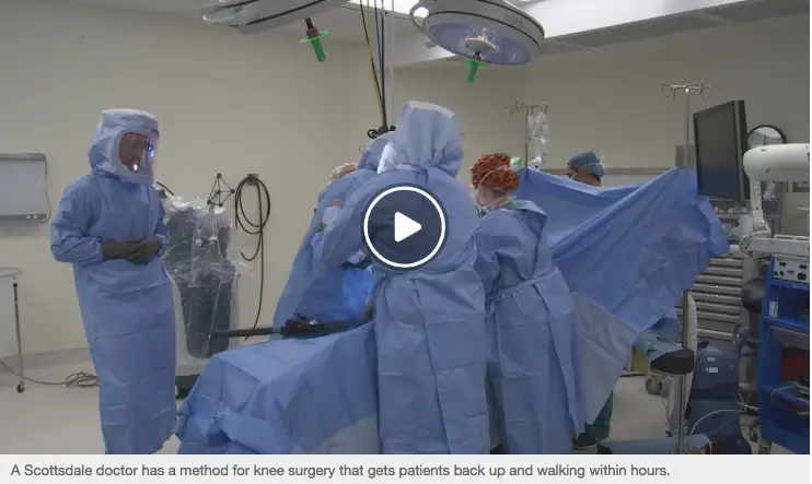 Video thumbnail — Scottsdale orthopedic surgical team performing a knee replacement procedure in a modern operating room, with caption noting patients are walking within hours of surgery