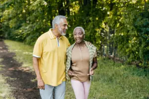 Senior couple walking together along a wooded park trail, representing pain-free mobility and everyday active living after hip or knee replacement surgery with Dr. Brandon Gough in Scottsdale Arizona